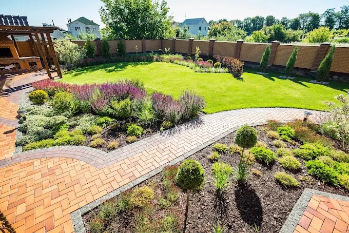 Backyard landscape design with paver walkway by JW Landscaping