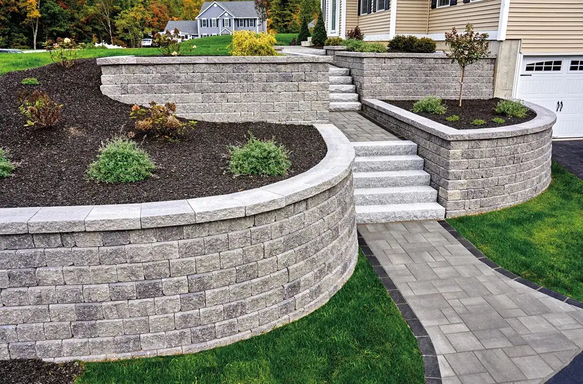 Tiered block retaining wall with paver steps by JW Landscaping