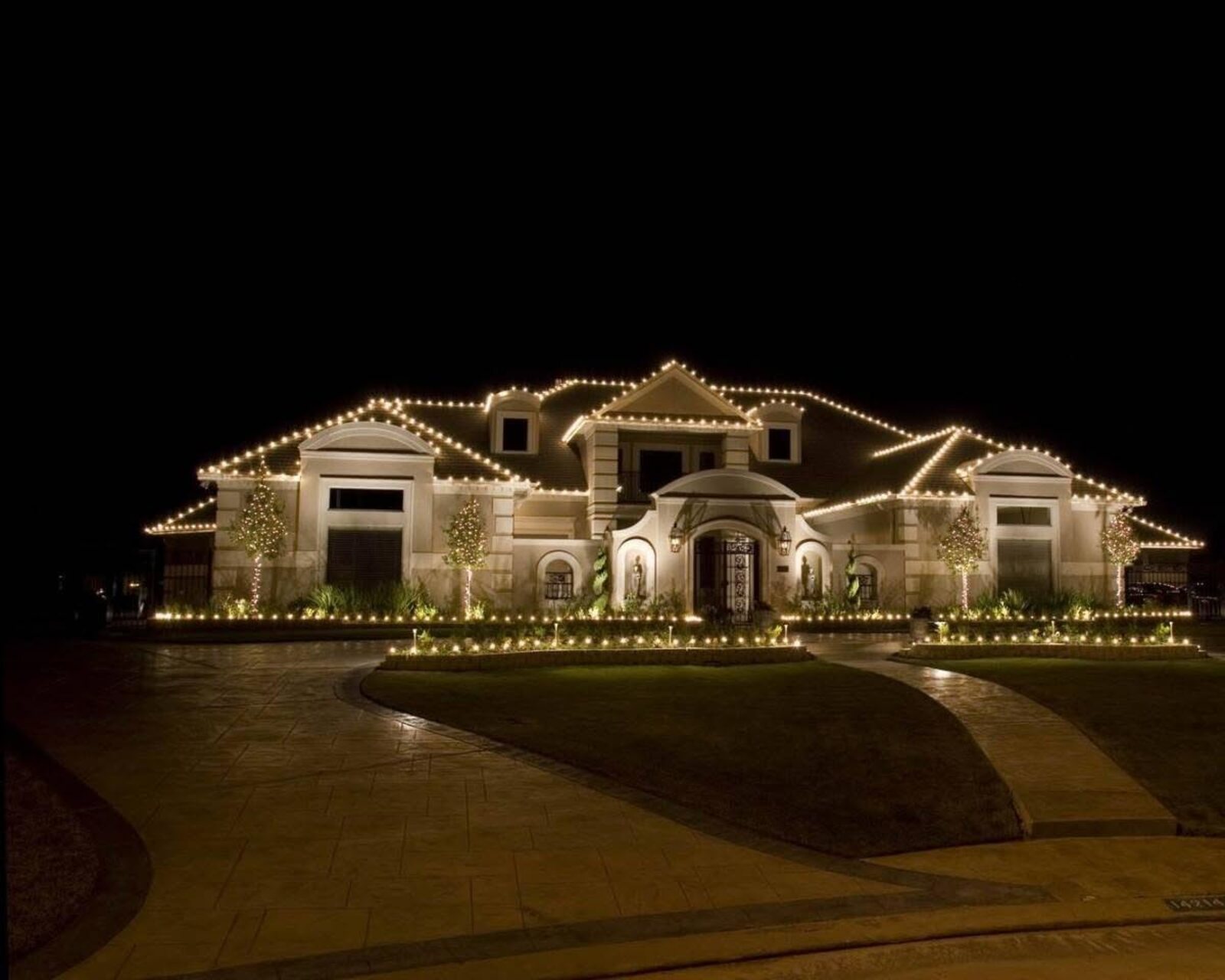 Large home with professional Christmas roofline lighting by JW Landscaping